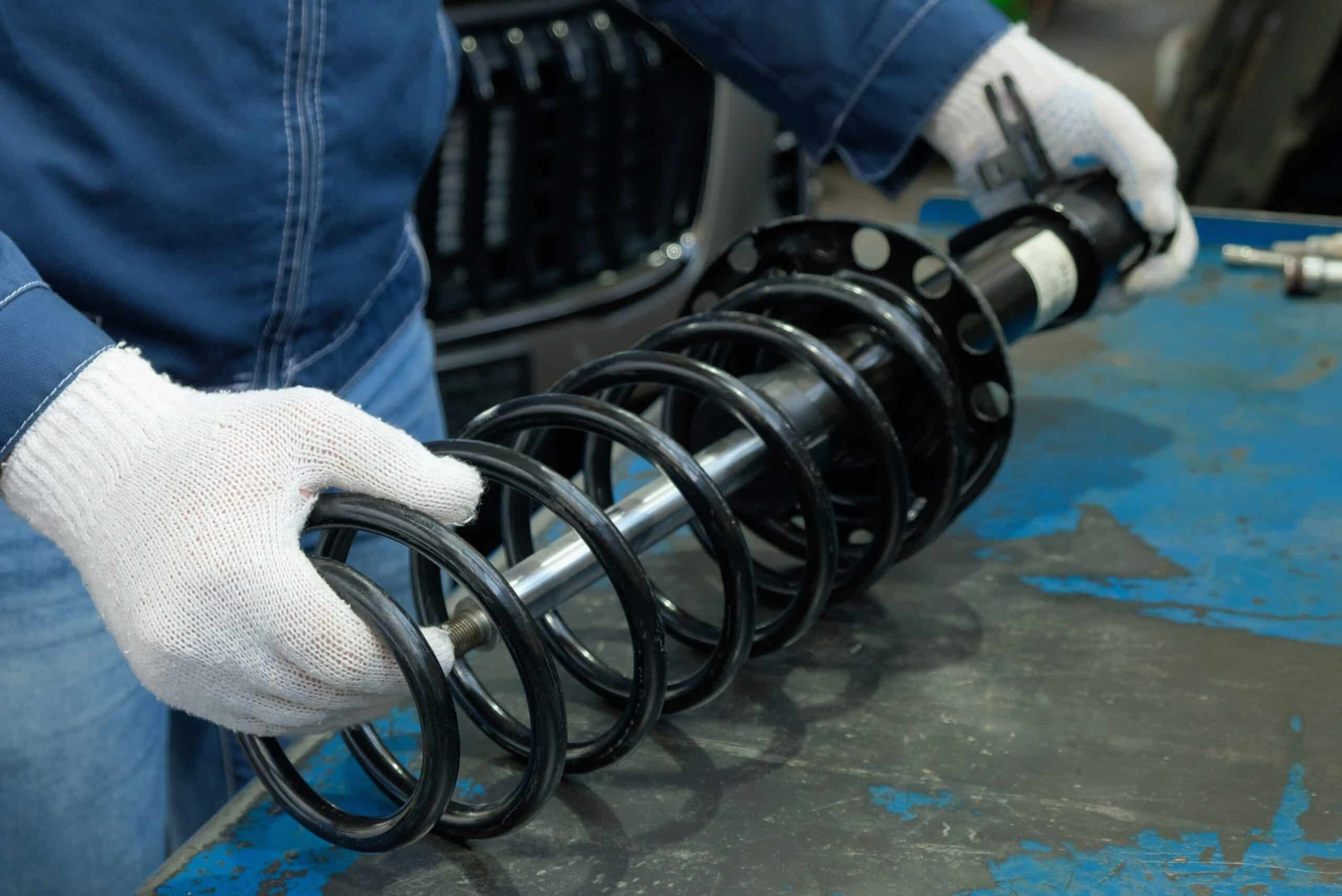 Maintenance at a car service station.Replacement of the shock absorber strut.An auto mechanic prepares and checks the compatibility of the shock strut and the spring.